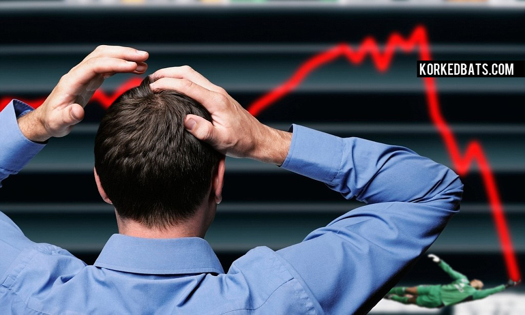 Stock Trader Clutching His Head in Front of a Screen Showing a Stock Market Crash